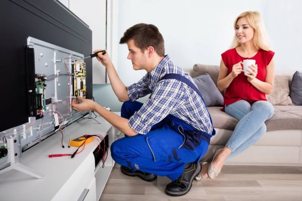 depositphotos 137860252 stock photo technician repairing television at home (1)